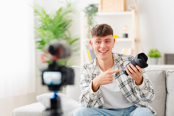 Young man recording video tutorial at home. Influencer showing product at camera.
