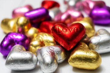 Multicolored heart shaped chocolates on a white background. close up. St. Valentine's Day Concept