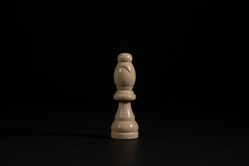 Isolated image of white bishop chess piece on black background.