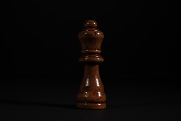 Obraz na płótnie Canvas Isolated image of brown queen chess piece on black background.
