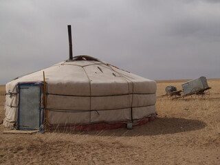 A Mongol nomadic tent (ger) in the serene steppe of eastern Sukhbaatar province, Mongolia. The nomadic family lives alone in the vast steppe of eastern Mongolia with their camels, horses, sheep, goats