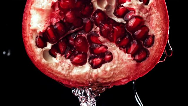Splashed water pours onto fresh pomegranates. Filmed on a high-speed camera at 1000 fps. High quality FullHD footage