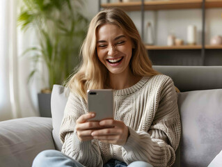 Happy relaxed young woman sitting on the sofa using smartphone at home. Smiling woman holding a mobile phone playing games, shopping online or watching videos on the sofa.
