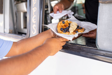 Buying a delicious waffle with fruits in a food truck - obrazy, fototapety, plakaty