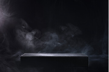 煙の立つ黒い空間にある四角い演壇