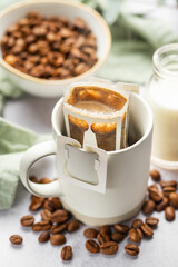 Drip coffee bag with ground coffee in  cup