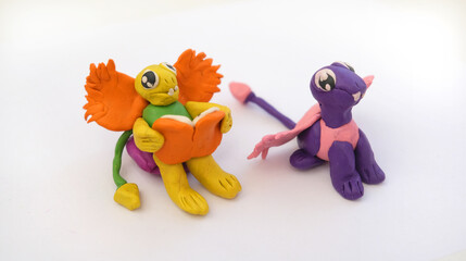 Child making colorful plasticine dragons family and creating. Fairy tale card with cartoon animals.