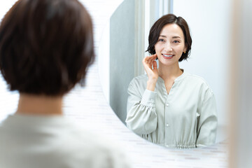 鏡を見て肌を触る日本人女性