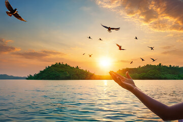 Palms open in worship, with birds soaring over a tranquil water sunset. Symbolizing the act of...