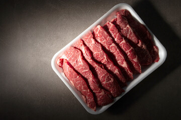 Sliced raw meat on dark background	