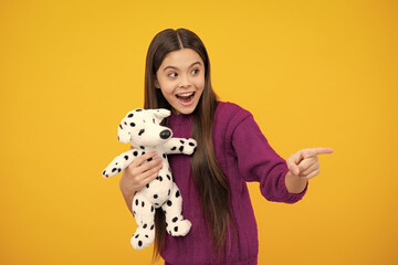 Excited face. Childhood, toys and kids. Cute teen girl cuddling fluffy toy. Amazed expression, cheerful and glad.