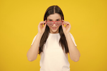 Woman feeling cool and awesome. Excited happy funny young woman in party glasses on a yellow bright...