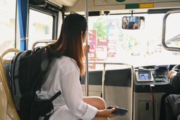 Female traveler with backpack sitting in public transportation. Travel lifestyle and transportation concept