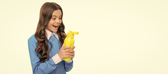 Surprised kid look at yellow plastic liquid bottle keeping mouth open isolated on white, fluid....