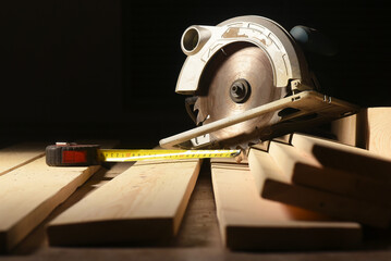 Circular saw and wooden boards close up background. Front view. Woodwork.