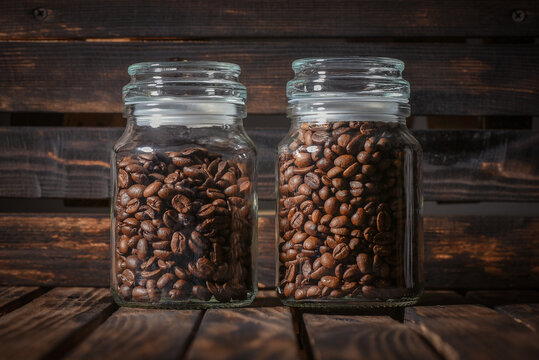 Coffee beans in the jar on the table front view close up background.