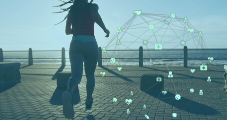 Image of network of connections over woman jogging on promenade by the sea