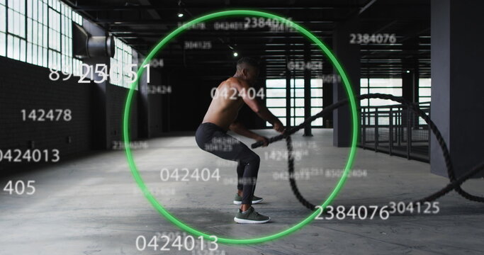 Image of green circle and floating numbers over man exercising with ropes