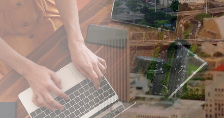 Image of caucasian businesswoman using laptop over cityscape