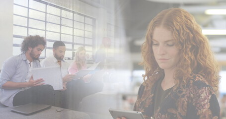 Image of diverse business people in office over cityscape