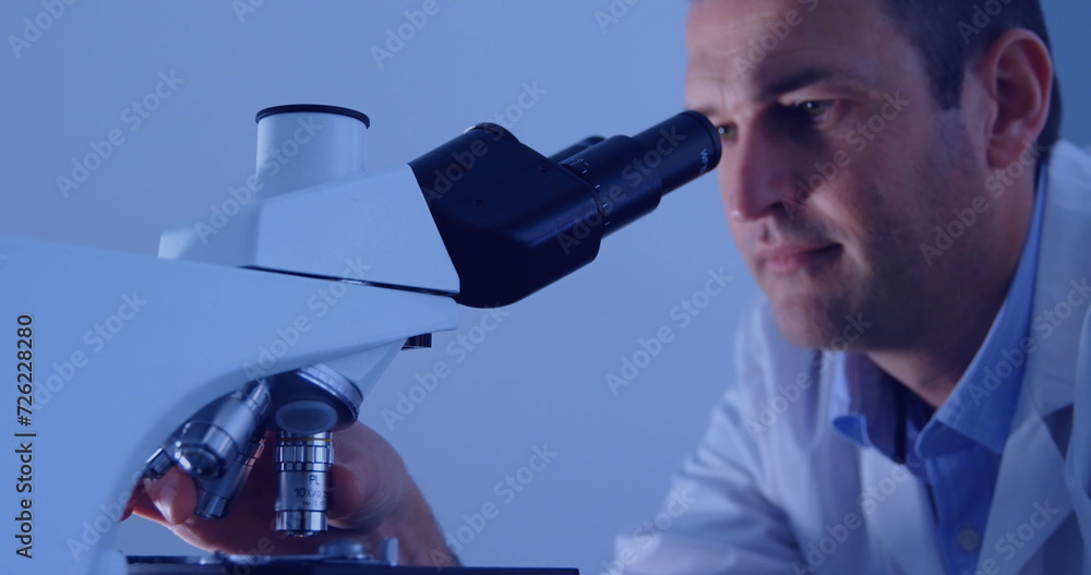 Poster image of data processing over caucasian male scientist using microscope