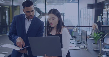 Naklejka premium Asian woman and young biracial man collaborate in a modern office