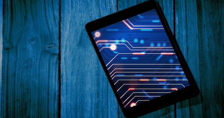 Image of tablet with data processing on blue background