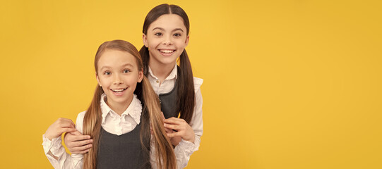 School girls friends. Happy school kids with beauty look wear long hair in formal uniforms yellow...