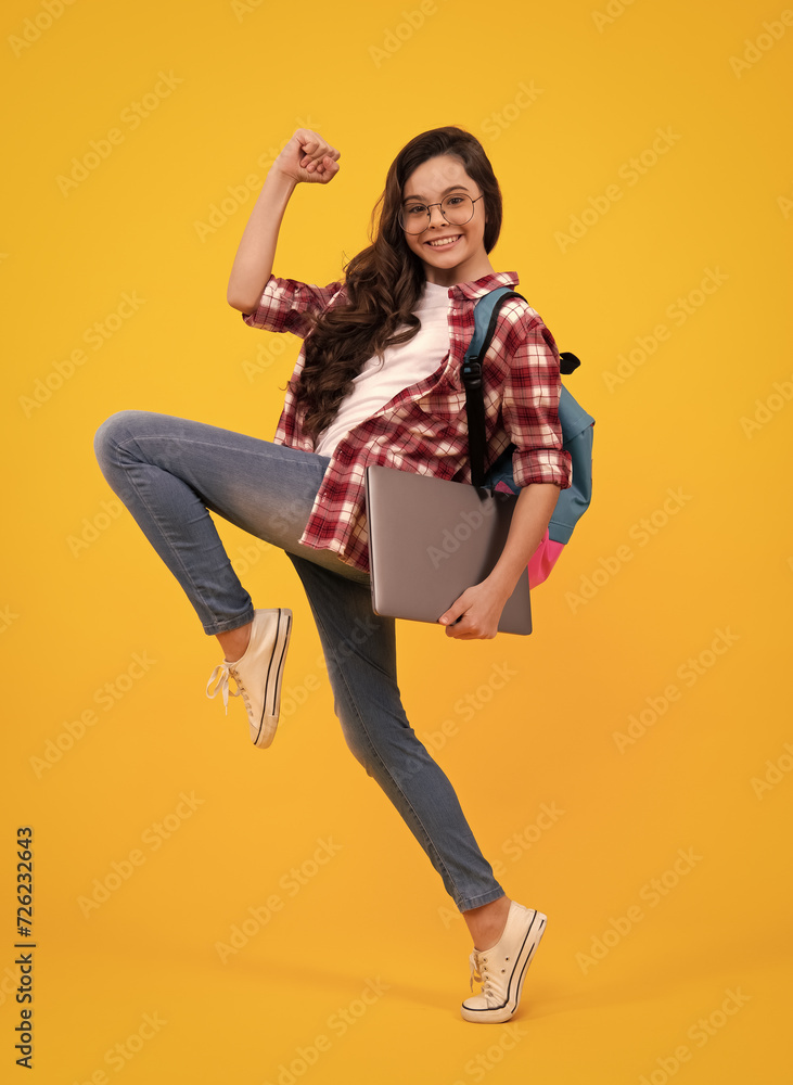 Poster back to school. teenager schoolgirl hold notebook laptop. school children on isolated yellow studio 