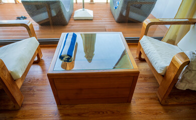 Wooden table with transparent glass on top.