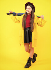 Teenager portrait full length. Fashion autumn kids weather. Child teenager girl with rainbow umbrella in autumn isolated on yellow background. Autumn kids trendy clothes.
