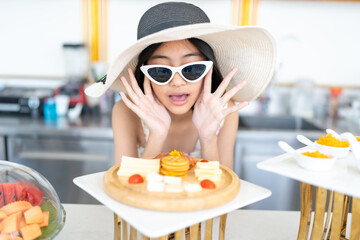 Asian female tourist Wow with the desserts that are placed in front of you on plates in the hotel...