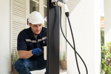 Qualified technician install home EV charging station, providing maintenance service for electric...