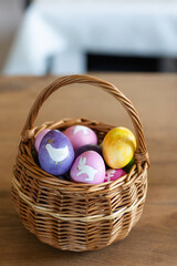 painted easter eggs in basket on table