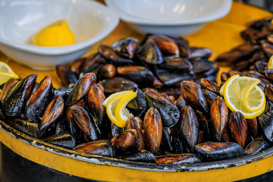 Fresh raw mussels with lemon on a platter waiting to be stuffed for traditional midye dolma at a restaurant, the Historic Peninsula, Istanbul, Turkey