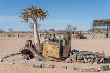 Quiver tree and vintage pickup body worn down by rust in exibition at Canyon Roadhouse, Namibia
