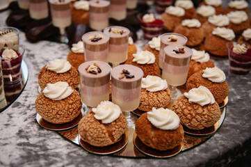 French Shu cake. Candy bar. Gourmet custard dessert. Festive sweet table with baking. Candy bar with desserts for celebrating birthday, baptism, wedding. Top view.