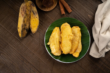 Deep fried sweet crispy banana or Pisang goreng on white plate and banana leaf