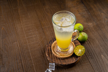 Cool freshly ice made mojito lemonade and lime on wooden coaster