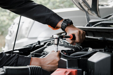 Mechanic fixing a car at home. Repair and service. - obrazy, fototapety, plakaty