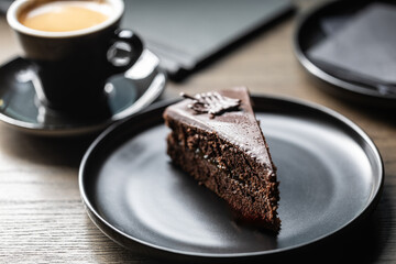 Sacher cake with coffee on the table in the cafe. - obrazy, fototapety, plakaty