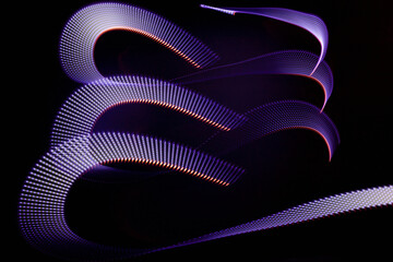 Violet and red glowing neon curved wave of light as curls with dotted stripes on black background, pattern. Abstract background with motion light effect in hipster style.