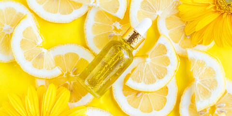 Essential oil, serum on textured background with yellow lemon slice