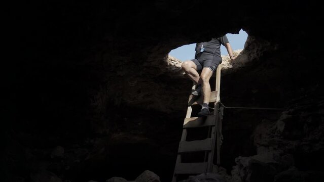 Man Descending into the Darkness of a Mysterious Cave