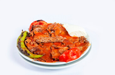 Top view of traditional Turkish cuisine food iskender kebab with melted butter, sauce, pita bread, tomato, pepper and yogurt isolated on white background.