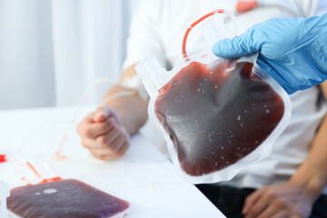 Bags with donor blood, donor and doctor's hand on light background, close up