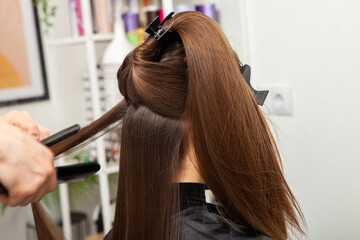 Naklejka premium Professional hairdresser cutting hair of young woman in beauty salon