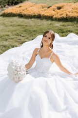 Beautiful bride with wedding flowers bouquet, attractive woman in wedding dress. Happy newlywed woman. Bride with wedding makeup and hairstyle. Smiling bride. Wedding day. Gorgeous bride. Marriage.