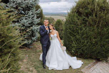 Happy couple celebrating their wedding outdoors. Amazing smiling wedding couple. Pretty bride and stylish groom. Wedding portrait.