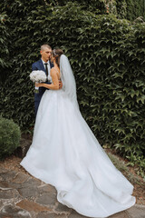 Close-up photo of a wedding couple looking each other in the eyes in nature. The bride and groom look each other in the middle of nature. Tenderness and love in the eyes.